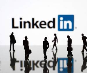 ?stanbul, Turkey - February 12, 2014: Human figurines standing in front of Apple iPad monitor displaying LinkedIn logo. LinkedIn is a social networking service for people in professional occupations.