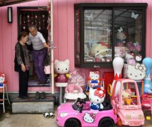 This photo taken on June 28, 2017 shows Masao Gunji, a retired police officer, standing at an entrance to his pink-painted Hello Kitty house with his wife Yoshiko Gunji (L) in Yotsukaido, Chiba prefecture.Gunji was recognised for the largest Hello Kitty collection (5,169 items) by the Guinness World Records in November 2016. / AFP PHOTO / AFPBB News / Yoko AKIYOSHI / - Japan OUT / -----EDITORS NOTE --- RESTRICTED TO EDITORIAL USE - MANDATORY CREDIT 'AFP PHOTO / Yoko AKIYOSHI' - NO MARKETING - NO ADVERTISING CAMPAIGNS - DISTRIBUTED AS A SERVICE TO CLIENTS