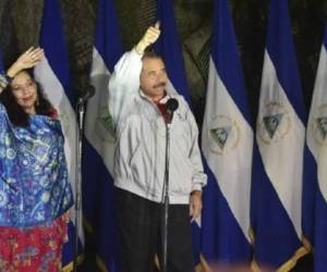 Nicaraguan President Daniel Ortega (R) and his wife Rosario Murillo wave after voting in Managua during the presidential election on November 6, 2016. Ortega and Murillo looked likely to win elections that would hand him a third straight term and cement her role as co-ruler. / AFP PHOTO / RODRIGO ARANGUA