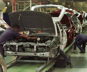 (ARCHIVOS) En esta foto de archivo tomada el 3 de febrero de 1999, trabajadores automotrices brasileños de Ford trabajan en la línea de ensamblaje de la planta automotriz de Sao Bernardo do Campo, en Sao Paulo, Brasil. - El fabricante de automóviles estadounidense Ford anunció el 11 de enero de 2021 el fin de la producción de vehículos en Brasil. (Foto de MARIE HIPPENMEYER / AFP)