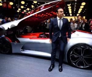 French carmaker Renault CEO Carlos Ghosn poses in front of the concept car Trezor on the first day of the press days of the Paris motor Show, on September 29, 2016. / AFP PHOTO / ERIC PIERMONT