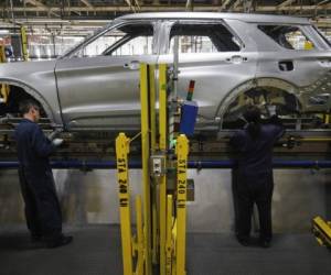(FILES) In this file photo taken on June 24, 2019 workers assemble cars at the newly renovated Ford's Assembly Plant in Chicago. - Moody's downgraded Ford's credit rating to speculative or 'junk' status September 9, 2019, citing the company's weak financial position as it embarks on an ambitious restructuring. (Photo by JIM YOUNG / AFP)
