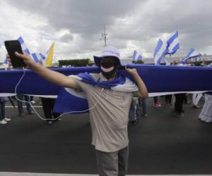 An anti-government protester takes part in a march dubbed 'Here nothing is normal', in Managua, on August 18, 2018.After four months of protests Nicaraguans demand president Daniel Ortega's resignation. / AFP PHOTO / INTI OCON