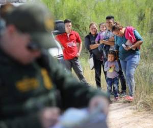 MCALLEN, TX - JUNE 12: Central American asylum seekers wait as U.S. Border Patrol agents take groups of them into custody on June 12, 2018 near McAllen, Texas. The families were then sent to a U.S. Customs and Border Protection (CBP) processing center for possible separation. U.S. border authorities are executing the Trump administration's zero tolerance policy towards undocumented immigrants. U.S. Attorney General Jeff Sessions also said that domestic and gang violence in immigrants' country of origin would no longer qualify them for political-asylum status. (Photo by John Moore/Getty Images)