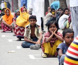 Bangladeshi street peoples gathered to collect foods sit in lines, adopting social distancing rules as they received relief materials provided by local community during the nationwide lockdown as a preventive measure against the COVID-19 coronavirus pandemic in Dhaka, Bangladesh on April 3, 2020. (Photo by Sipa USA)No Use UK. No Use Germany.