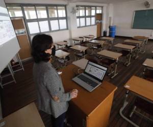 An unidentified teacher gives an online class amid the new coronavirus outbreak at Seoul girls' high school in Seoul, Thursday, April 9, 2020. Senior high school students begin school semester with online classes. Schools remain closed as part of measures taken by the government to stop the spread of the coronavirus. (AP Photo/Ahn Young-joon)
