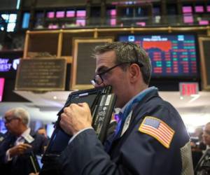 Traders y asesores financieros permanecen en la Bolsa de Valores de New York (NYSE) frente al campanazo de cierre el 10 de agosto de 2018. Drew Angerer/Getty Images/AFP