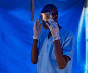 A member of South Sudanese Ministry of Health's Rapid Response Team puts on the eye protection before taking a sample from a man who has recently been in contact with a confirmed case of the COVID-19 coronavirus in Juba, South Sudan on April 13, 2020. - Four cases of the COVID-19 coronavirus have been confirmed among United Nations (UN) national and international staff in South Sudan. (Photo by Alex McBride / AFP)