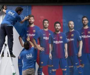 Two men put up a new poster outside the Camp Nou Stadium in Barcelona on August 2, 2017. The previous poster featured Barcelona's Brazilian forward Neymar. Neymar could be presented as a Paris Saint-Germain player as early as this weekend for a world record fee as Barcelona admitted defeat in convincing the Brazilian to stay at the Camp Nou on August 2. / AFP PHOTO / Josep LAGO