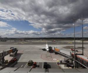 General view shows an airplane parked at a boarding finger at the Helmut-Schmidt-Airport in the northern German city of Hamburg on March 31, 2020 while air travel, as with most other industries, has been severly effected by the new coronavirus COVID-19 pandemic. (Photo by MORRIS MAC MATZEN / AFP)