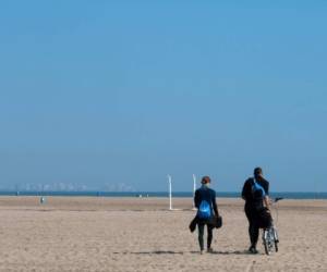 Poca gente camina en una playa en Valencia, España, luego que el país confirmó más de 1.500 nuevos casos de coronavirus entre el viernes y el sábado, elevando su total a 5.753 casos, el segundo número más alto en Europa después de Italia. Foto JOSE JORDAN / AFP)
