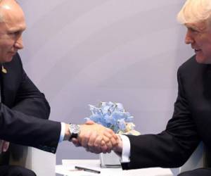 US President Donald Trump and Russia's President Vladimir Putin shake hands during a meeting on the sidelines of the G20 Summit in Hamburg, Germany, on July 7, 2017. / AFP PHOTO / SAUL LOEB