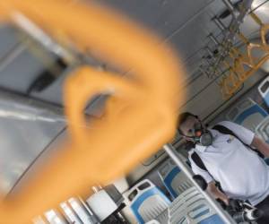 A worker disinfects a bus as a preventive measure against the spread of the new coronavirus, COVID-19, in San Jose, Costa Rica, on March 18, 2020. (Photo by Ezequiel Becerra / AFP)