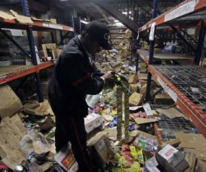 A security guard shows supermarket merchandise destroyed in 'La Union' Supermarket after lootings during protests against the government's reforms in the Institute of Social Security (INSS) in Managua on April 22, 2018. Nicaragua's President Daniel Ortega agreed Sunday to scrap a highly-controversial reform of the country's pension law that sparked four days of violence, leaving 24 people dead. / AFP PHOTO / INTI OCON