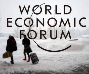 Two people leave the Congress Centre under snow ahead of the opening of the World Economic Forum (WEF) 2018 annual meeting, on January 22, 2018 in Davos, eastern Switzerland.US President Donald Trump's participation at the World Economic Forum in Davos, Switzerland next week could be thrown into question now that the federal government has partially shut down over budget wrangling, the White House said on January 20. / AFP PHOTO / Fabrice COFFRINI