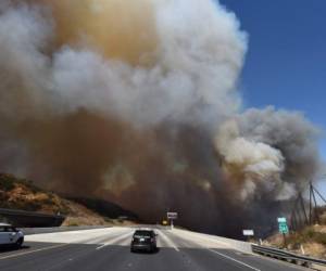 Una patrulla bloquea la autopista 241 por la densidad del humo que sale de uno de los incendios que azotan a California.