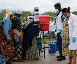 Burundians wash their hands, as a preventive measure against the COVID-19 coronavirus, on their arrival of their repatriation in Gatumba, on the border with the Democratic Republic of Congo, in Burundi, on March 18, 2020. (Photo by Onesphore NIBIGIRA / AFP)