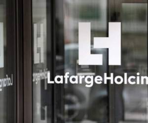 (FILES) This file photo taken on March 9, 2017 in Paris shows the company's logo at an entrance of the French headquarters of LafargeHolcim, a group created in 2015 by the merger of French cement manufacturer Lafarge and its Swiss counterpart Holcim.Eric Olsen, who as been serving as Chairman and Chief Executive Officer of LafargeHolcim since July 10, 2015, will step down on July 15, 2017 following an internal investigation into a plant the Swiss-French cement company operated in Syria until September 2014. / AFP PHOTO / Thomas SAMSON