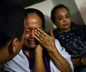 Algunos familiares de las personas que viajaban a bordo del avión de Malaysia Airlines derribado en Ucrania lloran su pérdida en Yakarta, el 18 de julio de 2014. (Foto: AFP)