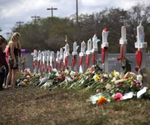 Varias personas dejan ofrenda floral frente a la Marjory Stoneman Douglas High School, en Parkland, Florida. Donde un joven radical de 19 años asesinó a 17 personas.
