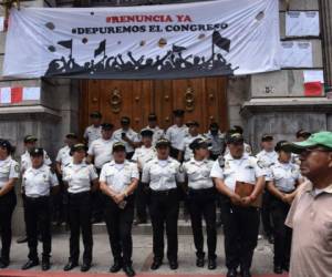Police officers stand guard outside the National Congress during a protest against the government policies on the International Commission Against Impunity in Guatemala (CICIG), on September 11, 2018, in Guatemala City.Guatemala President Jimmy Morales ordered the head of a United Nations anti-corruption commission be blocked from entering the Central American country just four days after shutting down the mission. The head of the International Commission Against Impunity in Guatemala (CICIG), Colombian Ivan Velasquez will continue to direct its work from outside the country after he was barred from re-entering by President Jimmy Morales' government. / AFP PHOTO / Johan ORDONEZ