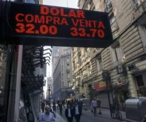 Currency exchange values are displayed in the buy-sell board of a bureau de exchange in Buenos Aires, on August 29, 2018.Argentina's President Mauricio Macri said Wednesday that the International Monetary Fund has agreed to accelerate funding in support of his government's austerity program. The development came amid heightened volatility in the South American country's financial and currency markets, which have been battered by uncertainty over inflation, an economic downturn and budget deficits. / AFP PHOTO / EITAN ABRAMOVICH