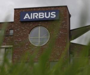 The Airbus logo can be seen on a building next to the main entrance of the Hamburg plant of European aircraft maker Airbus is seen on July 8, 2020. - Airbus said it is planning to cut around 15,000 jobs worldwide, 11 percent of its total workforce, in response to the 'gravest crisis' the industry has ever seen. (Photo by MORRIS MAC MATZEN / AFP)