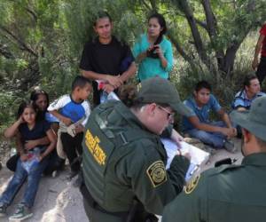 MCALLEN, TX - JUNE 12: Central American asylum seekers wait as U.S. Border Patrol agents take groups of them into custody on June 12, 2018 near McAllen, Texas. The families were then sent to a U.S. Customs and Border Protection (CBP) processing center for possible separation. U.S. border authorities are executing the Trump administration's zero tolerance policy towards undocumented immigrants. U.S. Attorney General Jeff Sessions also said that domestic and gang violence in immigrants' country of origin would no longer qualify them for political-asylum status. John Moore/Getty Images/AFP