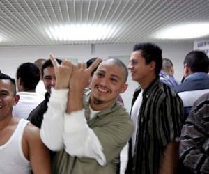 Un grupo de salvadoreños deportados desde Estados Unidos gesticulan cuando llegan al aeropuerto Internacional de El Salvador en noviembre de 2006. AFP PHOTO / YURI CORTEZ