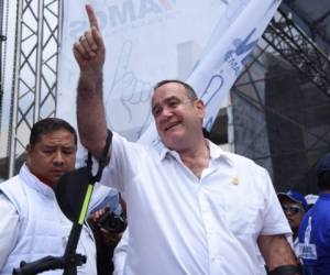 Guatemalan candidate for the Vamos party Alejandro Giammattei (C) gestures to supporters during his campaign closing rally in Guatemala City on August 4, 2019. - Giammattei will face the candidate for the National Union of Hope (Union Nacional de la Esperanza) party Sandra Torres in a run-off election on August 11. (Photo by ORLANDO ESTRADA / AFP)