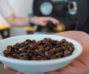 Empleada de la empresa asociativa ARUCO en Copán, muestra el café tras proceso de tostado.