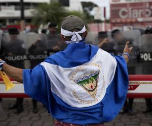 <i>Fotografía de un joven con una bandera de Nicaragua frente a Policías, en Managua (Nicaragua). EFE/Jorge Torres</i> <i>Fotografía de un joven con una bandera de Nicaragua frente a Policías, en Managua (Nicaragua). EFE/Jorge Torres</i>