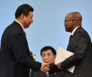 Los presidentes chino, Xi Jinping (i), y sudafricano, Jacob Zuma, se estrechan la mano en la Cumbre de los BRICS, en Fortaleza. (Foto: AFP).