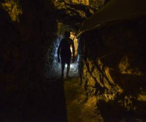 A man walks in a tunnel at a gold mine in El Callao, Bolivar state, southeastern Venezuela on March 1, 2017. - Although life in the mines of eastern Venezuela is hard and dangerous, tens of thousands from all over the country head for the mines daily in overcrowded trucks, pushed by the rise in gold prices and by the severe economic crisis affecting the country, aggravated recently by the drop in oil prices. (Photo by JUAN BARRETO / AFP) / TO GO WITH AFP STORY by Maria Isabel SANCHEZ