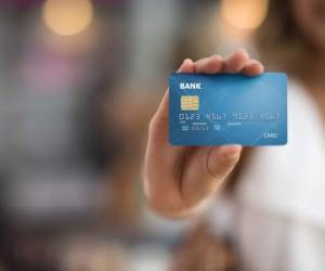 Female shopper holding a credit card - focus on foreground. Credit card, design and number are own creations
