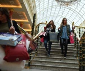 Compradoras caminan en el centro comercial Trafford en Manchester, al norte de Ingleterra el 27 de noviembre. AFP PHOTO / OLI SCARFF