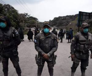 Policías custodian el paso en un camino vecinal en Alotenango, Sacatepequez, unos 65 km al sureste de Ciudad de Guatemala. Las autoridades se concentran en la búsqueda de desaparecidos y restringir el paso de particulares a las zonas más afectadas.