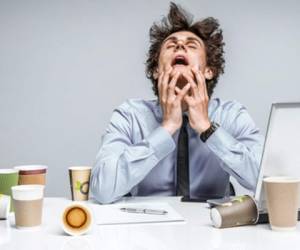 53343522 - omg! frustrated man sitting desperate over paper work at desk. negative emotion facial expression feeling