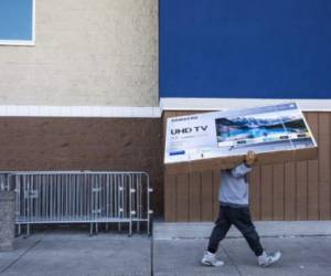EMERYVILLE, CA - NOVEMBER 29: A Black Friday shopper carries a newly purchased television to his car, outside a Best Buy store on November 29, 2019 in Emeryville, United States. Black Friday is traditionally the biggest shopping event of the year, and marks the beginning of the holiday shopping season. Philip Pacheco/Getty Images/AFP