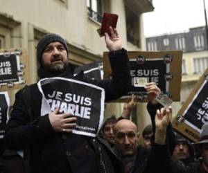 Un grupo de periodistas muestra sus carnés de prensa durante el minuto de silencio que observaron por la matanza de Charlie Hebdo. (Foto: AFP).