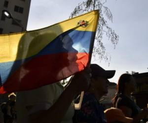 A supporter of Venezuelan opposition leader and self-proclaimed interim president Juan Guaido holds a Venezuelan flag before a rally at El Paraiso neighbourhood in Caracas on April 05, 2019. - US Vice President Mike Pence announced sanctions Friday on 34 vessels of Venezuela's state oil company and two companies that ship crude to Cuba as Washington pushes to oust President Nicolas Maduro. (Photo by Yuri CORTEZ / AFP)
