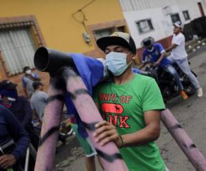 An anti-government demonstrator carries a makeshift mortar during protests in the town of Masaya, 35 km from Managua on June 5, 2018.From little boys with skinny arms to old women with creased faces, it seems everyone in Masaya, Nicaragua is ready to go to war. Toting home-made mortars, their faces covered with balaclavas and bandanas, the young men of Masaya stand guard at myriad barricades, determined to keep out President Daniel Ortega's riot police -- whom they accuse of pillaging the city and massacring its people. / AFP PHOTO / INTI OCON