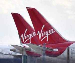 (FILES) In this file photo taken on April 02, 2020 tailfins of parked Virgin Atlantic passenger aircraft are pictured on the apron at Heathrow Airport, west of London. - Virgin Atlantic will only survive the coronavirus outbreak if it gets financial support from the British government, the airlines founder Richard Branson said on April 20, 2020. (Photo by Ben STANSALL / AFP)