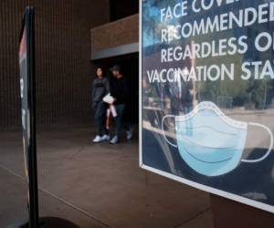 PHOENIX, ARIZONA - DECEMBER 18: A sign asks visitors to wear a mask in downtown Phoenix where new COVID-19 cases are down but health experts warn cases may rise with the introduction of the omicron strain on December 18, 2021 in Phoenix, Arizona. According to the Arizona Department of Health Services, since mid-December 2020 over 14,000 people have died of COVID-19 in Arizona. Arizona Governor Doug Ducey has signed an executive order banning local governments from imposing the vaccine requirements. Arizona does not yet have a mask mandate and mask use is sporadic. Spencer Platt/Getty Images/AFP (Photo by SPENCER PLATT / GETTY IMAGES NORTH AMERICA / Getty Images via AFP)