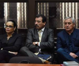 El expresidente Otto Pérez Molina (derecha) y la exvicepresidenta Roxana Baldetti (izquierda) junto al abogado César Calderón (C). Tras dos años de detención previsional la justicia de Guatemala ordenó procesarolos judicialmente por corrupción.