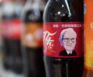 A Cherry Coke bottle featuring an image of US investor Warren Buffet is seen on a shelf at a convenience store in Beijing on April 5, 2017.The likeness of billionaire Warren Buffett has graced Cherry Coke cans in China, where the company's largest investor enjoys a legendary reputation. Coca-Cola announced over the weekend that a grinning cartoon portrait of the American business magnate would adorn cans and bottles of his favourite flavour after it was introduced in the country on March 10. / AFP PHOTO / GREG BAKER