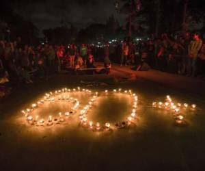 Activistas indonesios encienden velas y forman el 60+ en las actividades por la Hora del Planeta.