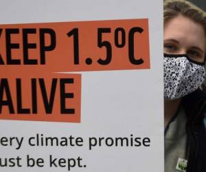 Una activista climática sostiene un cartel mientras protesta durante la Conferencia de Cambio Climático COP26 de la ONU en Glasgow el 12 de noviembre de 2021. Un borrador de declaración de la cumbre COP26 el viernes pidió a las naciones que alivien su dependencia de los combustibles fósiles mientras las conversaciones entraban en sus últimas horas sin señal de lograr los recortes de emisiones necesarios para limitar el calentamiento global a 1,5 ° C. Foto AFP