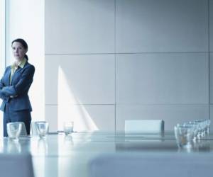 Businesswoman standing alone in conference room