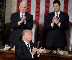 US Vice President Mike Pence (L), US President Donald Trump (C) and Speaker of the House Paul Ryan (R-WI) clap during a joint session of Congress on Capitol Hill February 28, 2017 in Washington, DC. / AFP PHOTO / Brendan Smialowski